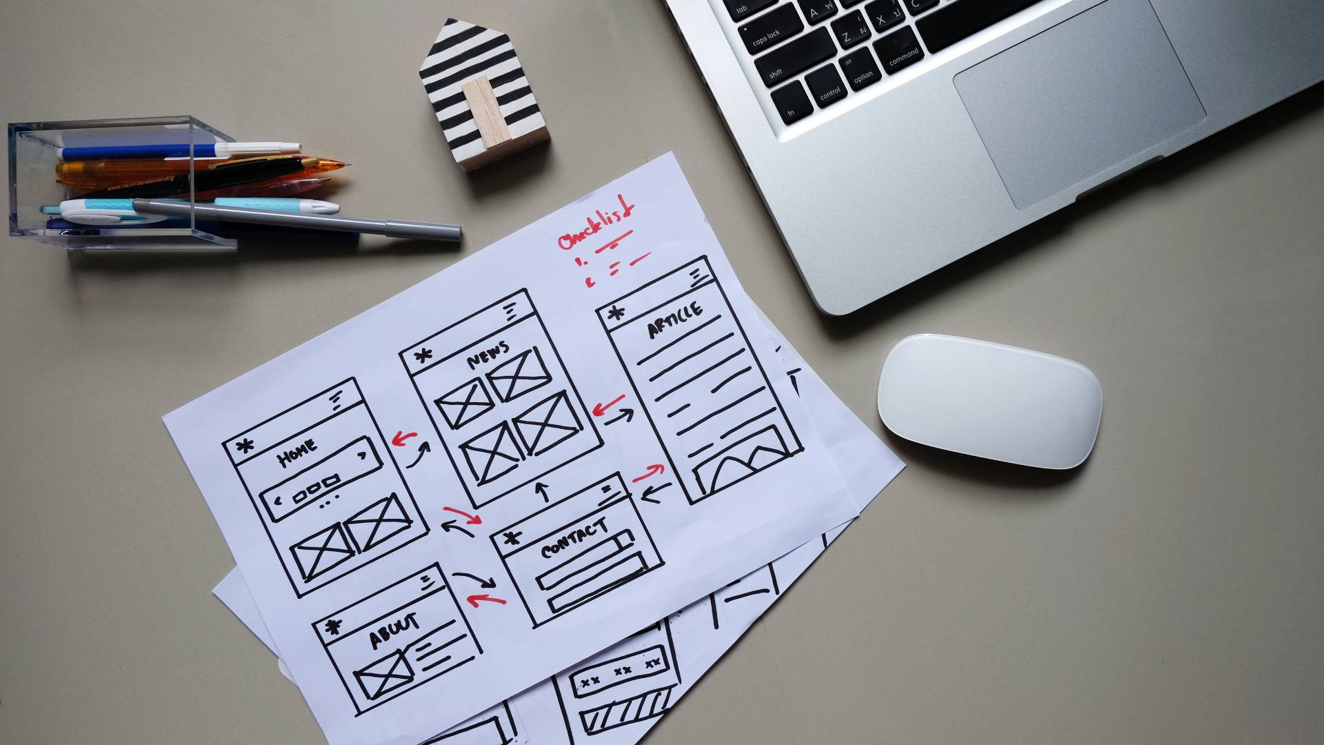 About Plan Website wireframe sketches on paper beside a laptop
